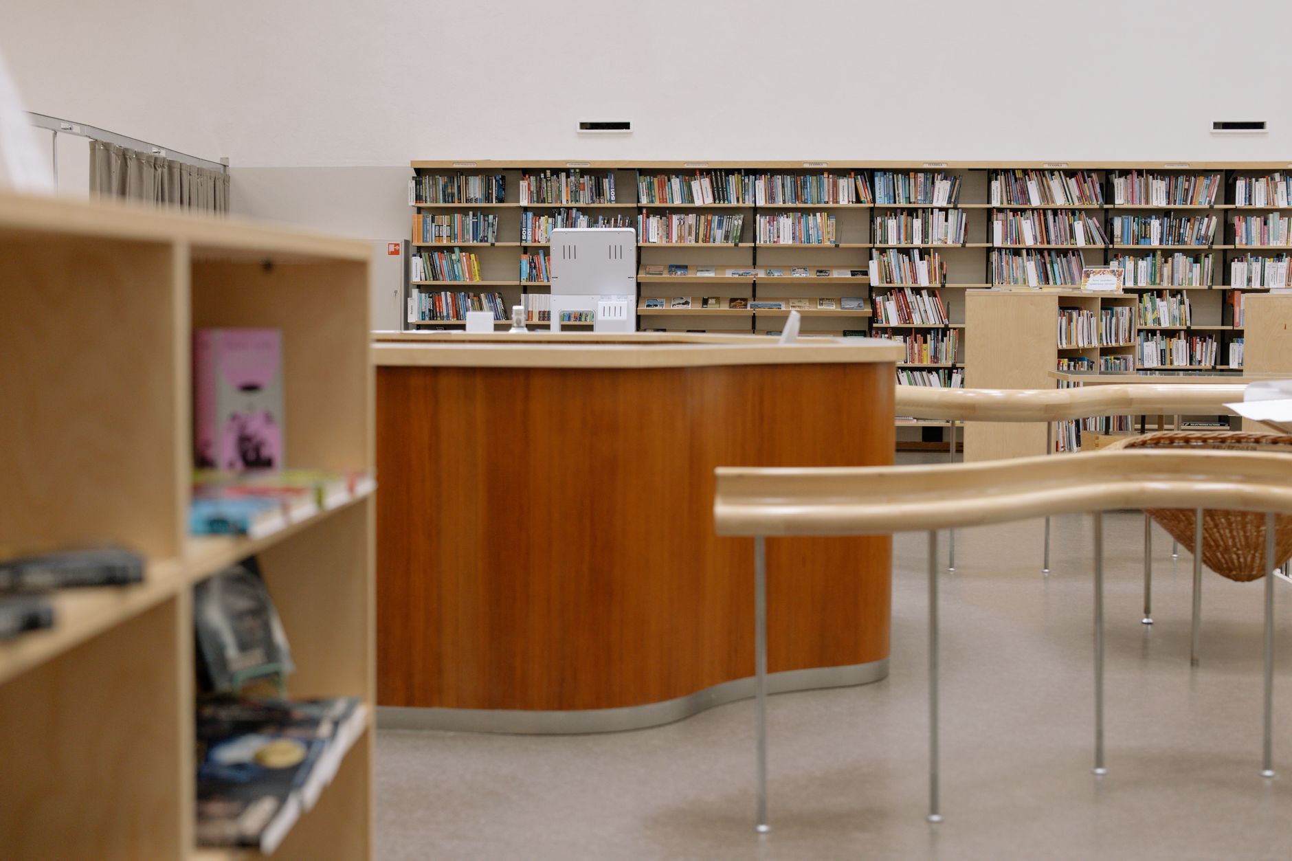 Library service desk in front of rows of bookshelves.